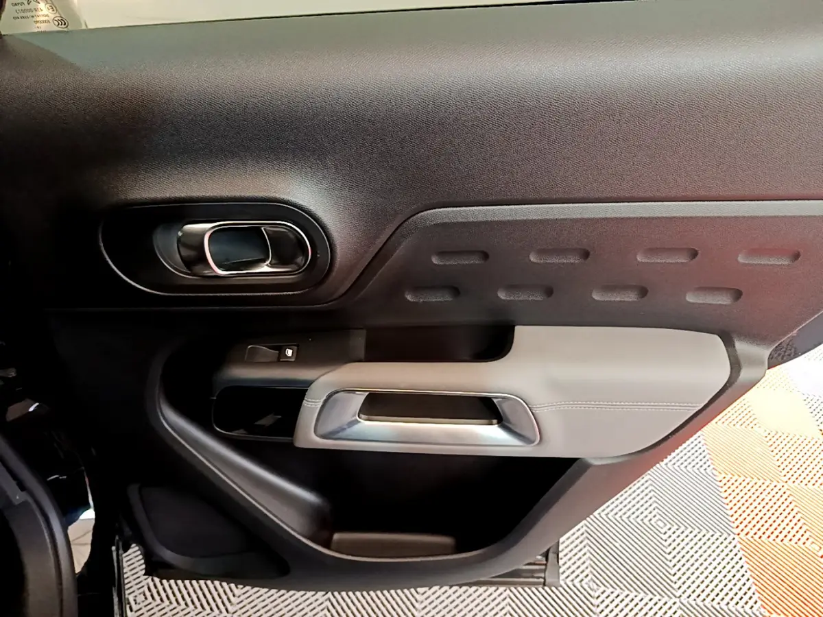 Gros plan sur la porte intérieure côté gauche noire et grise du Citroën C5 Aircross avec poignée argentée.