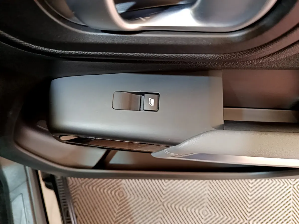 Détail de la commande de lève-vitre côté conducteur dans l'habitacle noir du Citroën C5 Aircross 2020.