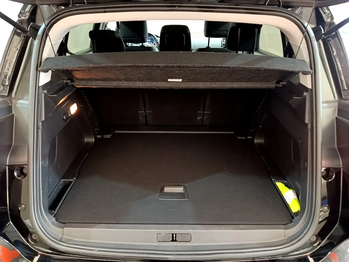 Coffre ouvert d'un Citroën C5 Aircross noir, vue arrière, montrant un espace de chargement spacieux et bien éclairé.