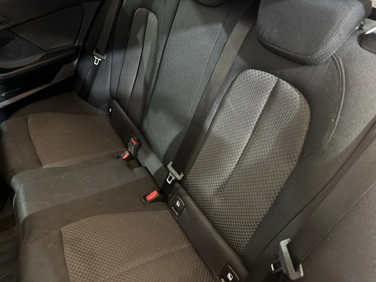 Vue rapprochée des sièges arrière noirs en tissu de la BMW Série 1 116d Business Design 2022.