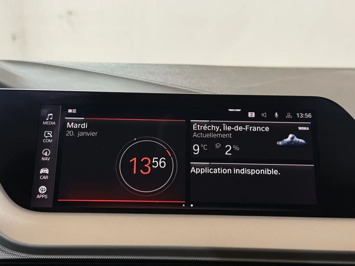 Affichage numérique central tactile de la BMW Série 1 116d Business Design, avec heure, météo et menus visibles.