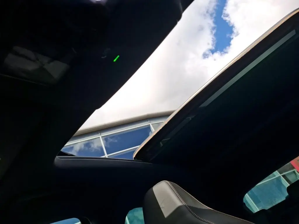 Vue intérieure du toit ouvrant panoramique du CUPRA Formentor gris clair 2024, avec ciel bleu visible à travers l'ouverture.