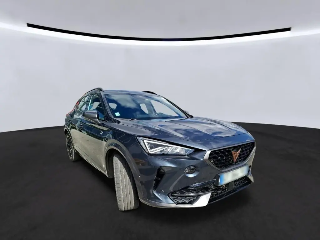 Vue 3/4 avant d'une CUPRA Formentor 1.4 E-HYBRID 245 VZ gris clair avec calandre noire et détails chromés.