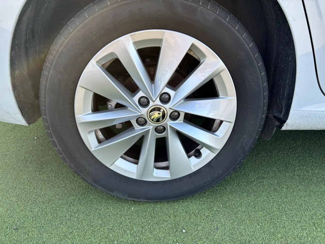 Gros plan sur la jante alliage argent Sargas Aero 16 pouces d'une Skoda Scala blanc glacier côté gauche.