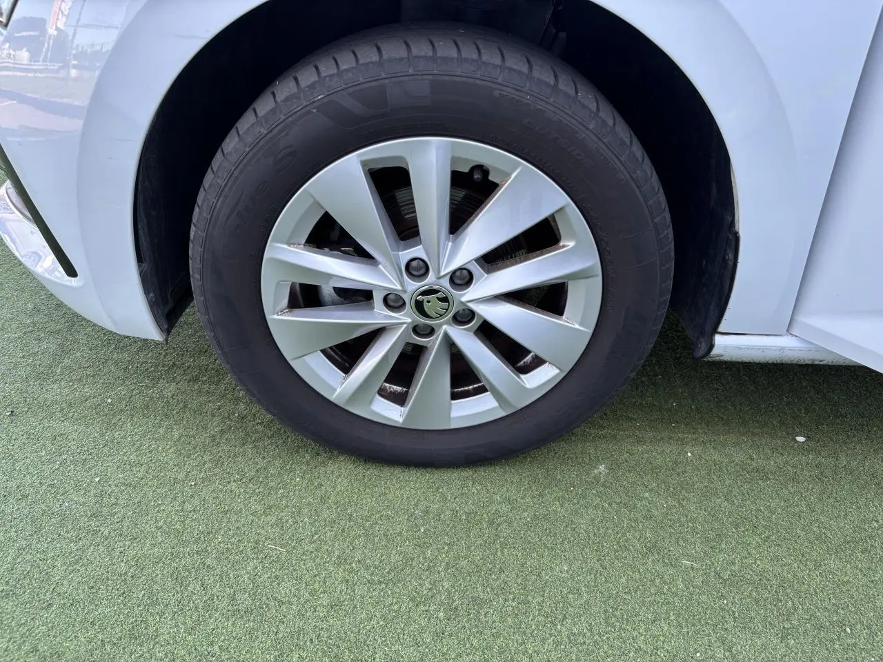 Gros plan sur la roue avant gauche blanche glacier d'une Skoda Scala 2024 avec jante alliage argent Sargas Aero.