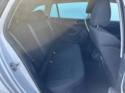 Vue intérieure arrière côté gauche de la banquette noire d'une Skoda Scala Blanc Glacier 2024 avec ceintures et appuie-têtes visibles.