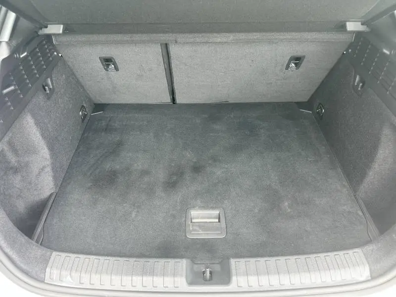 Coffre spacieux et propre de l'Audi A3 Sportback blanc Arkona, vue intérieure arrière avec banquette rabattable.