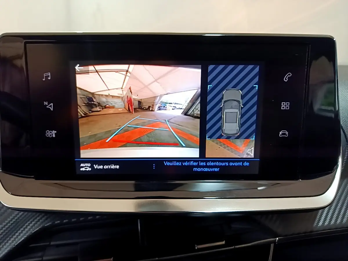 Écran tactile du Peugeot 2008 gris clair montrant la caméra de recul et l'affichage de l'aide au stationnement.