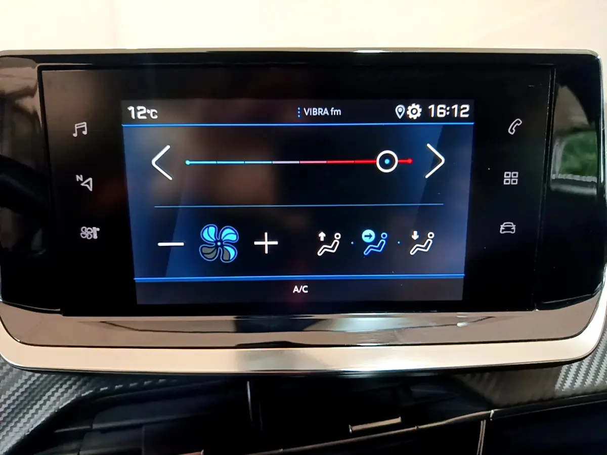 Écran tactile central du tableau de bord du Peugeot 2008 gris clair, affichant les réglages de climatisation à 16h12.