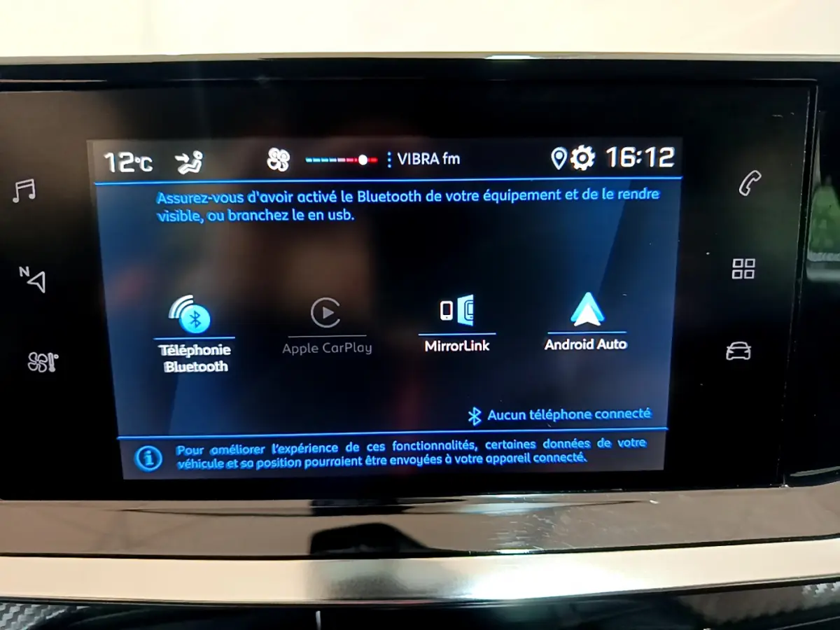 Écran tactile central du tableau de bord du Peugeot 2008 gris clair, affichant les options Bluetooth et Apple CarPlay.