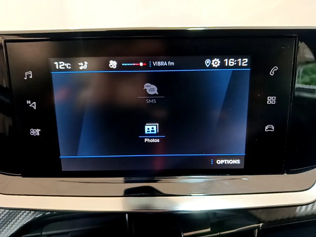Écran tactile central affichant la radio et options multimédia dans le tableau de bord d'une Peugeot 2008 gris clair.