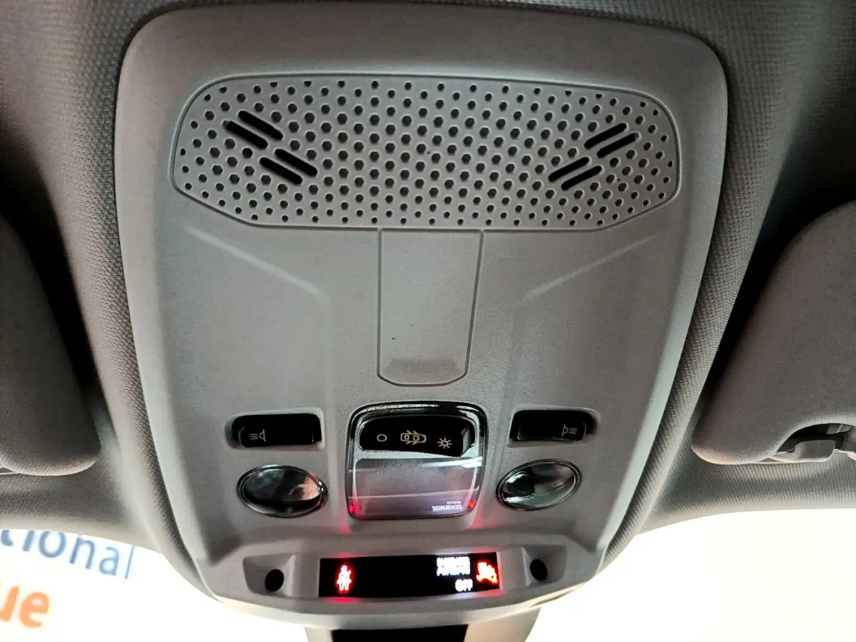 Vue en contre-plongée du plafonnier gris clair du Peugeot 2008 avec commandes d'éclairage et haut-parleur intégré.