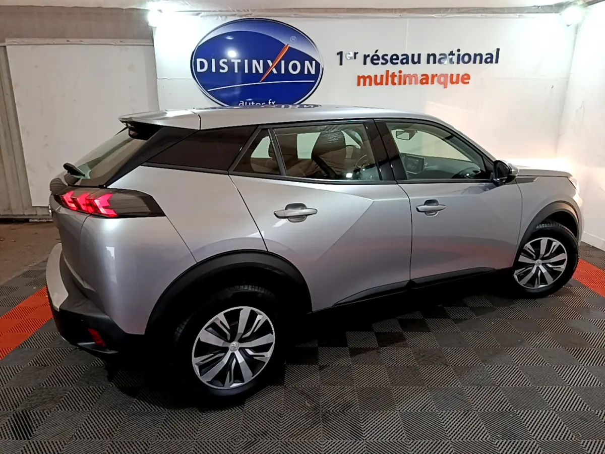 Peugeot 2008 BlueHDi 110 S&S Active gris clair vu de profil côté droit en intérieur showroom.