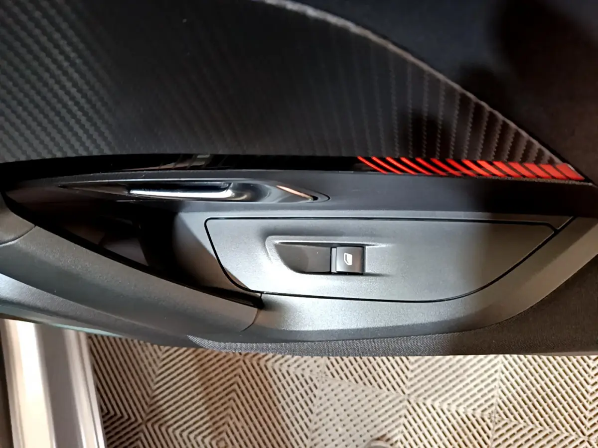 Détail de la commande de lève-vitre côté conducteur sur la porte intérieure gris clair du Peugeot 2008 BlueHDi 110 S&S Active 2022.