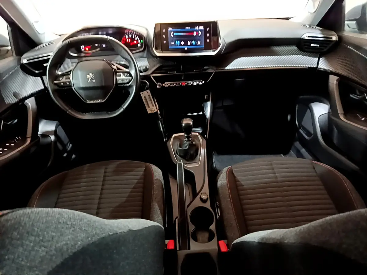 Intérieur noir du Peugeot 2008 BlueHDi 110 S&S Active 2022, vue avant centrée sur tableau de bord et volant cuir.