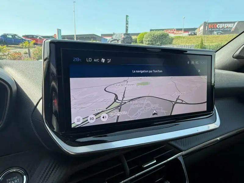 Vue intérieure du tableau de bord du Peugeot 2008 rouge Elixir 2025, mettant en avant l'écran tactile de navigation.