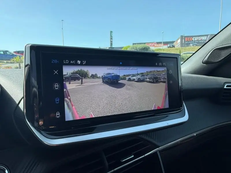 Écran central du Peugeot 2008 Hybrid rouge Elixir montrant la caméra de recul avec vue arrière du véhicule.