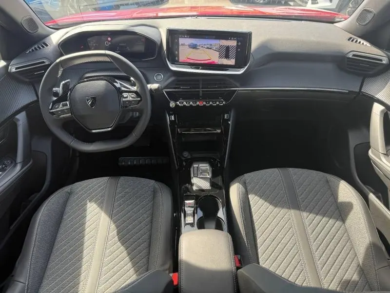Vue intérieure avant du Peugeot 2008 1.2 Hybrid 145ch Allure 2025, avec tableau de bord moderne et écran tactile central.