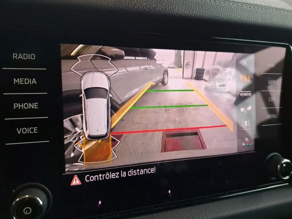 Écran de caméra de recul du Skoda Kodiaq gris clair montrant le côté droit du véhicule avec lignes de guidage colorées.