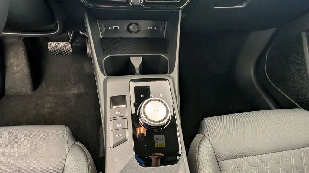 Vue rapprochée de la console centrale noire de la MG3 1.5 L Hybrid+ 2026 avec molette de boîte automatique et sièges gris.
