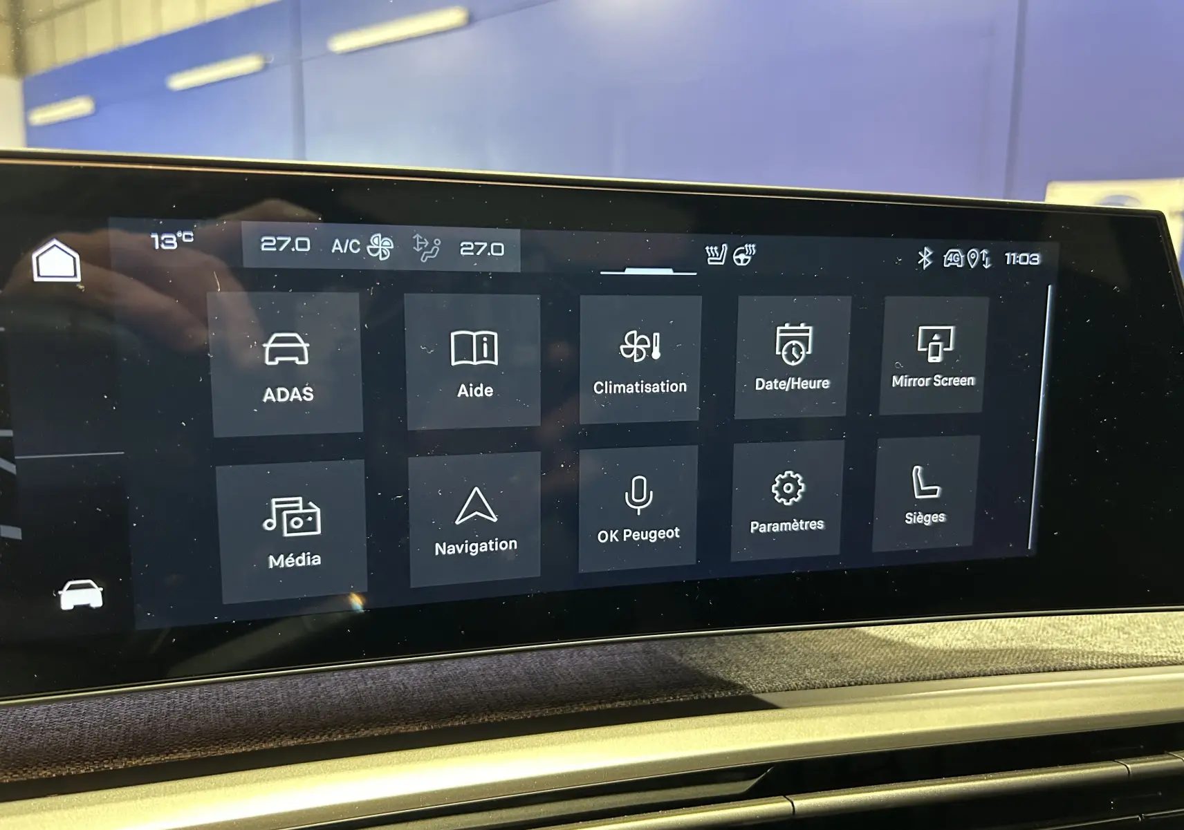 Écran tactile central du tableau de bord du Peugeot 3008 Hybrid 2026 affichant les menus de climatisation, navigation et aides à la conduite.