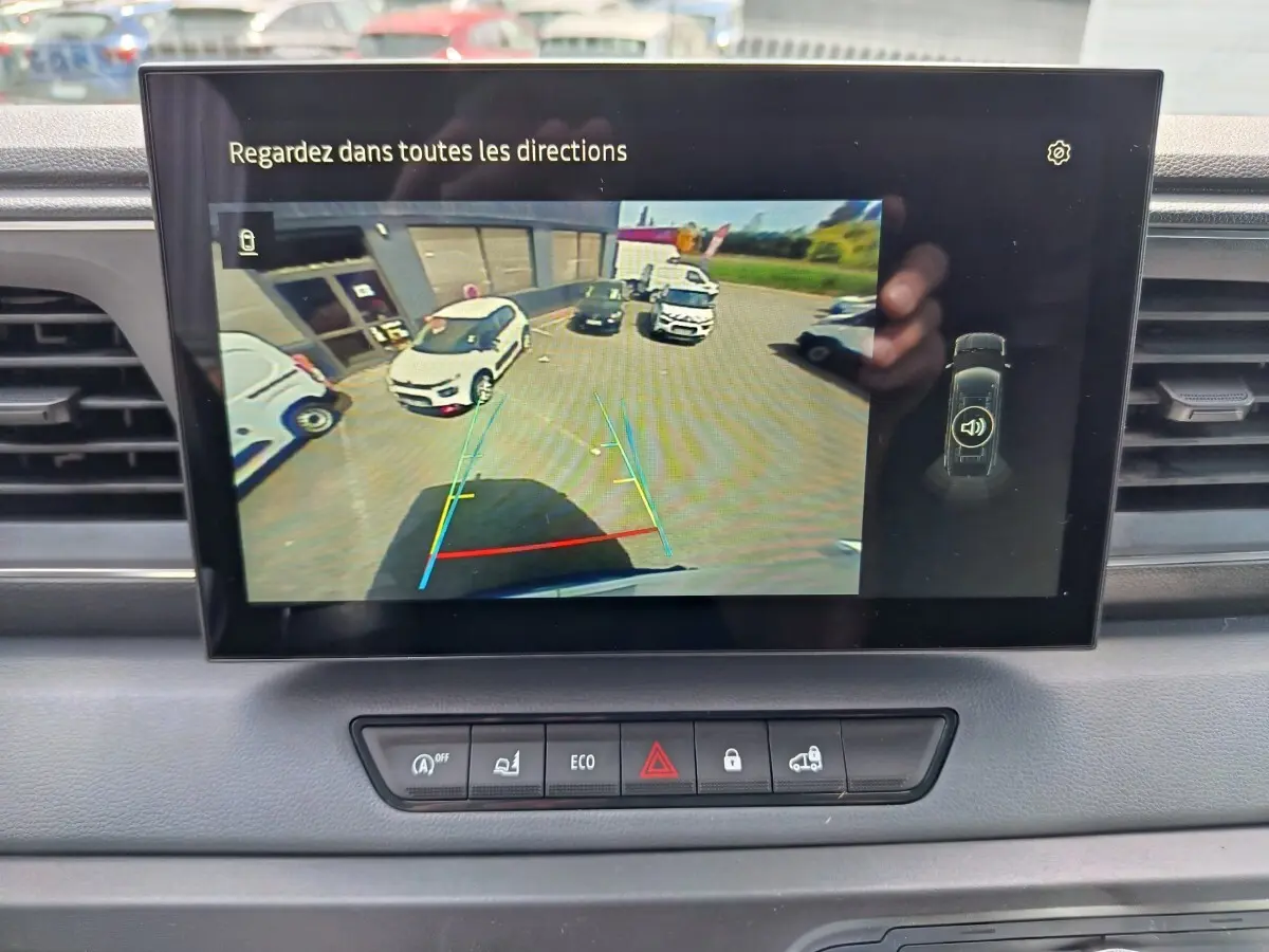 Écran tactile du tableau de bord du Renault Master 2025 montrant la caméra de recul avec vue arrière du véhicule blanc.