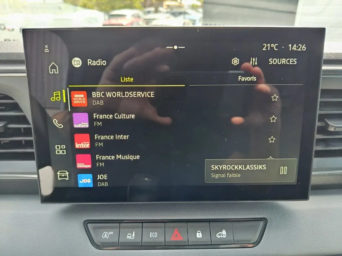 Écran tactile central du tableau de bord du Renault Master 2025 affichant les stations radio, avec commandes en dessous.