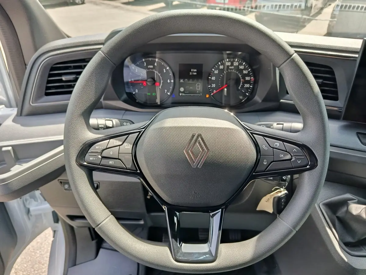 Vue rapprochée du volant noir du Renault Master 2025 avec commandes intégrées et tableau de bord numérique.