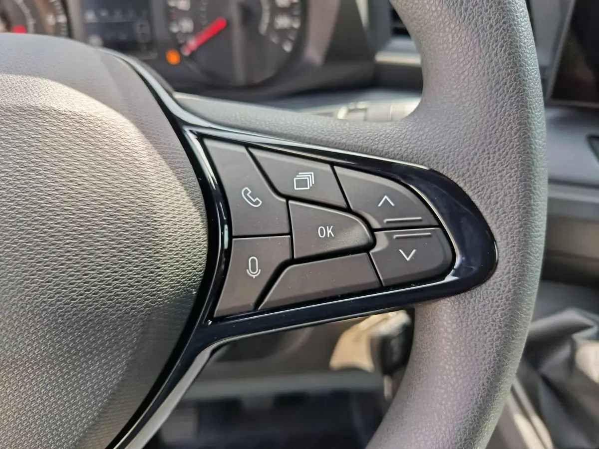 Gros plan sur les commandes multifonctions noires du volant côté droit du Renault Master blanc 2025.