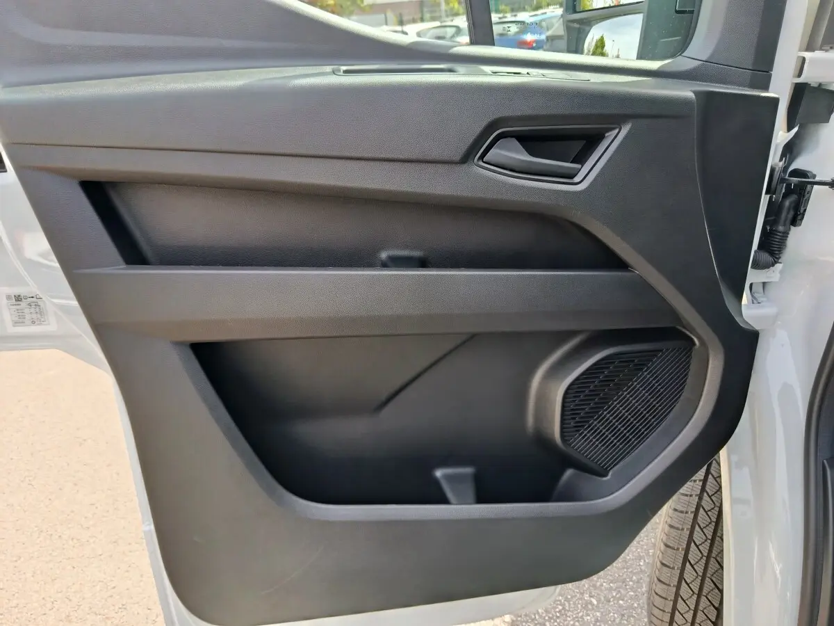 Vue rapprochée de la porte avant droite du Renault Master blanc 2025, avec haut-parleur intégré et poignée noire.
