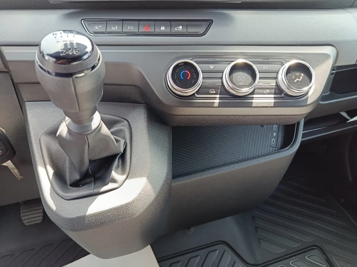 Gros plan intérieur sur la boîte manuelle et les commandes de climatisation du Renault Master blanc 2025.