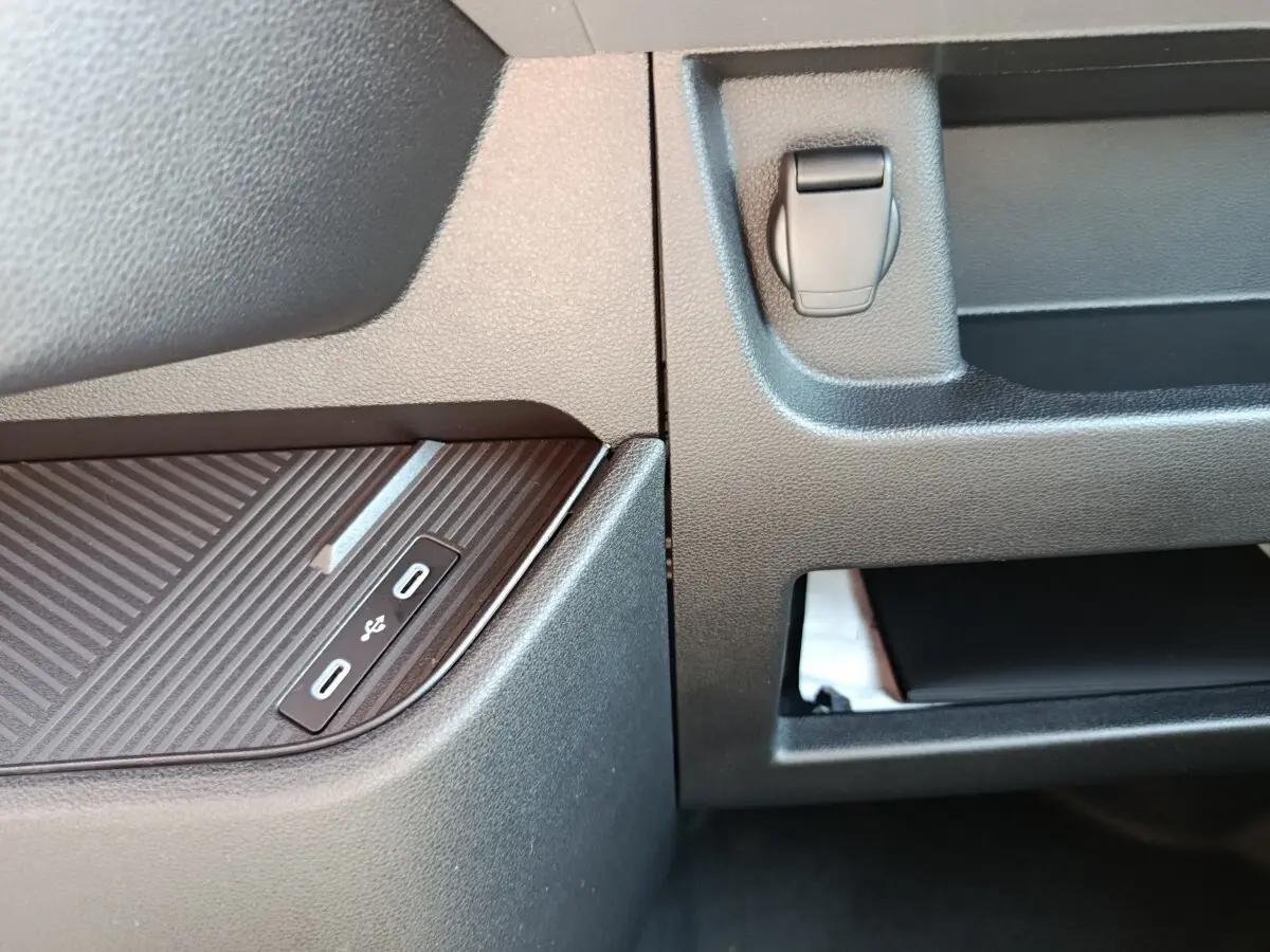Gros plan sur la console centrale intérieure du Renault Master blanc, montrant deux ports USB-C et un rangement ouvert.