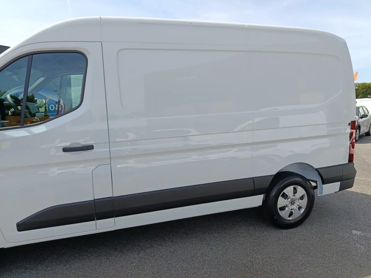 Vue latérale droite du Renault Master blanc, fourgon utilitaire avec jantes acier et protections noires sur les bas de caisse.