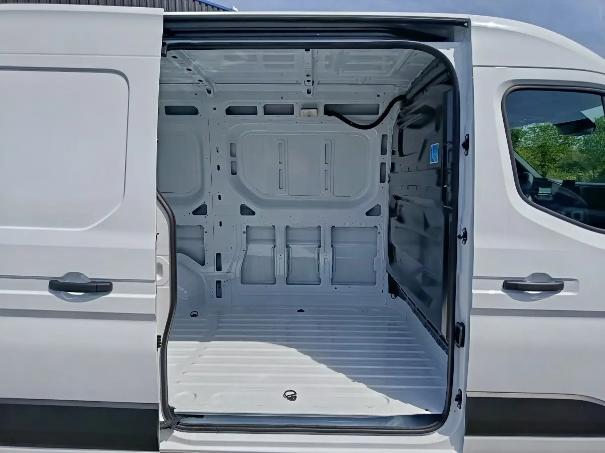 Vue latérale droite du Renault Master blanc 2025 avec porte coulissante ouverte montrant l'espace de chargement vide.