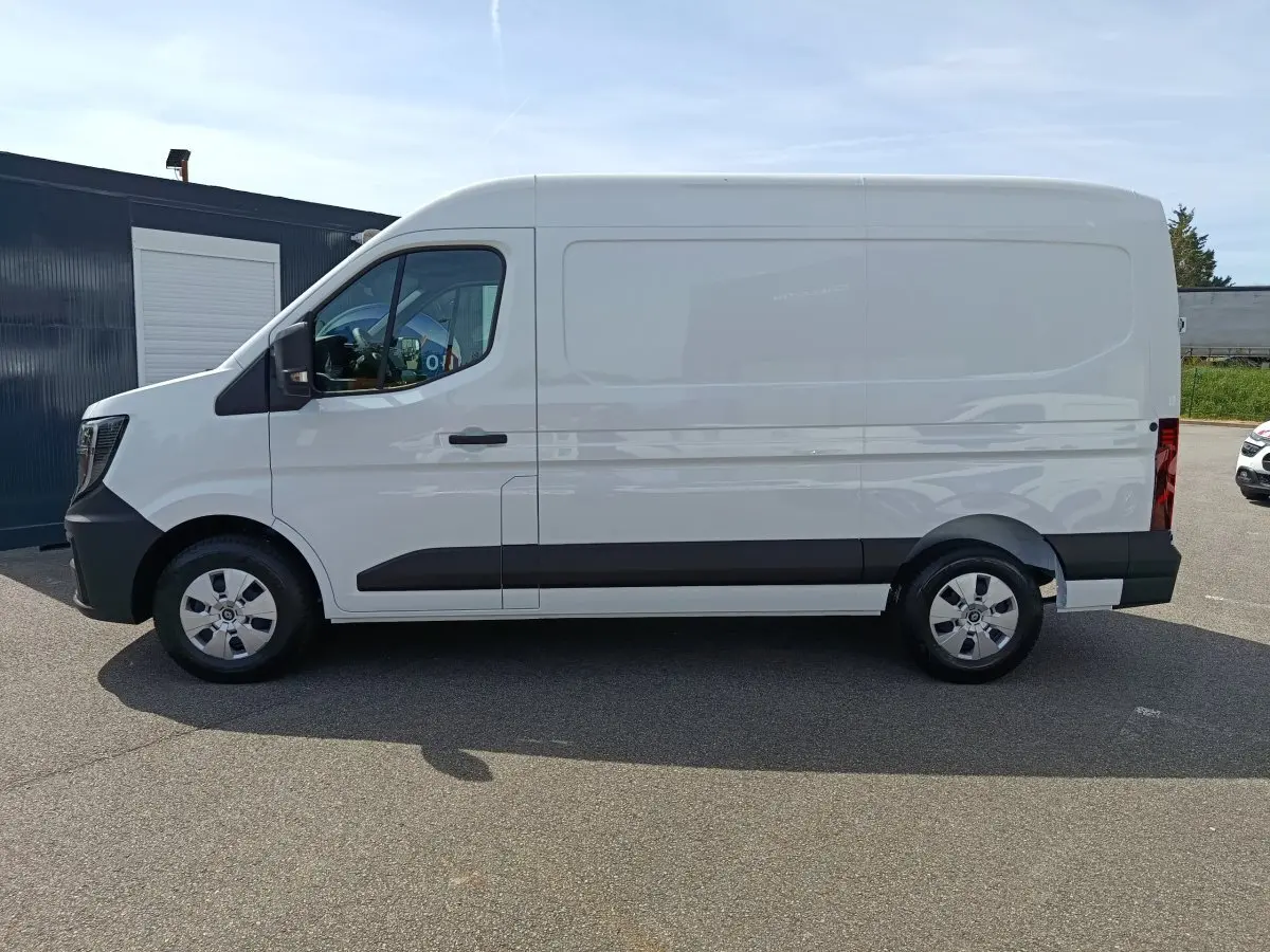 Vue latérale gauche d’un utilitaire Renault Master blanc avec bande noire le long de la porte coulissante.