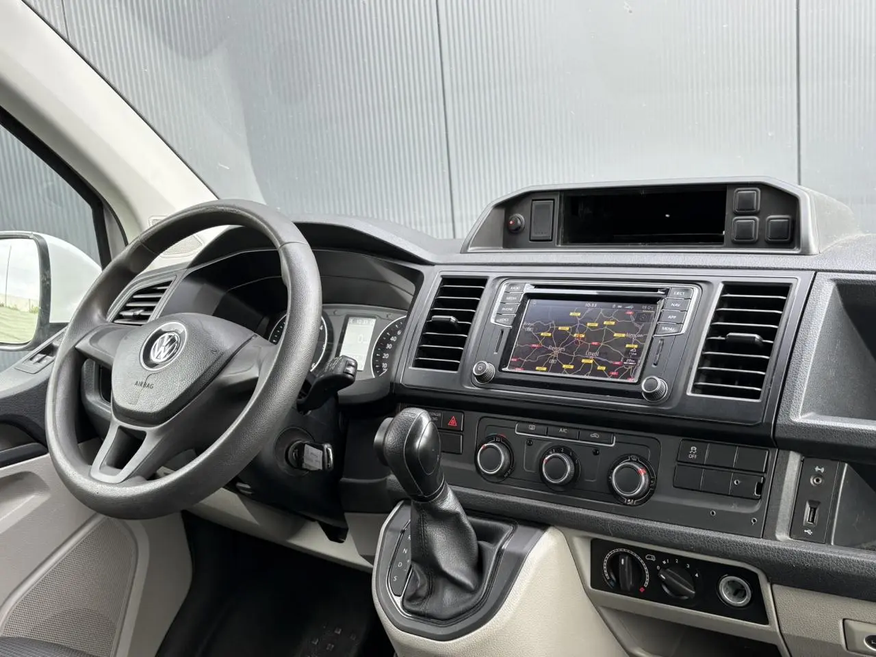 Vue intérieure du tableau de bord du Volkswagen Transporter 2.0 TDI 2017 avec volant, écran tactile et commandes de climatisation.
