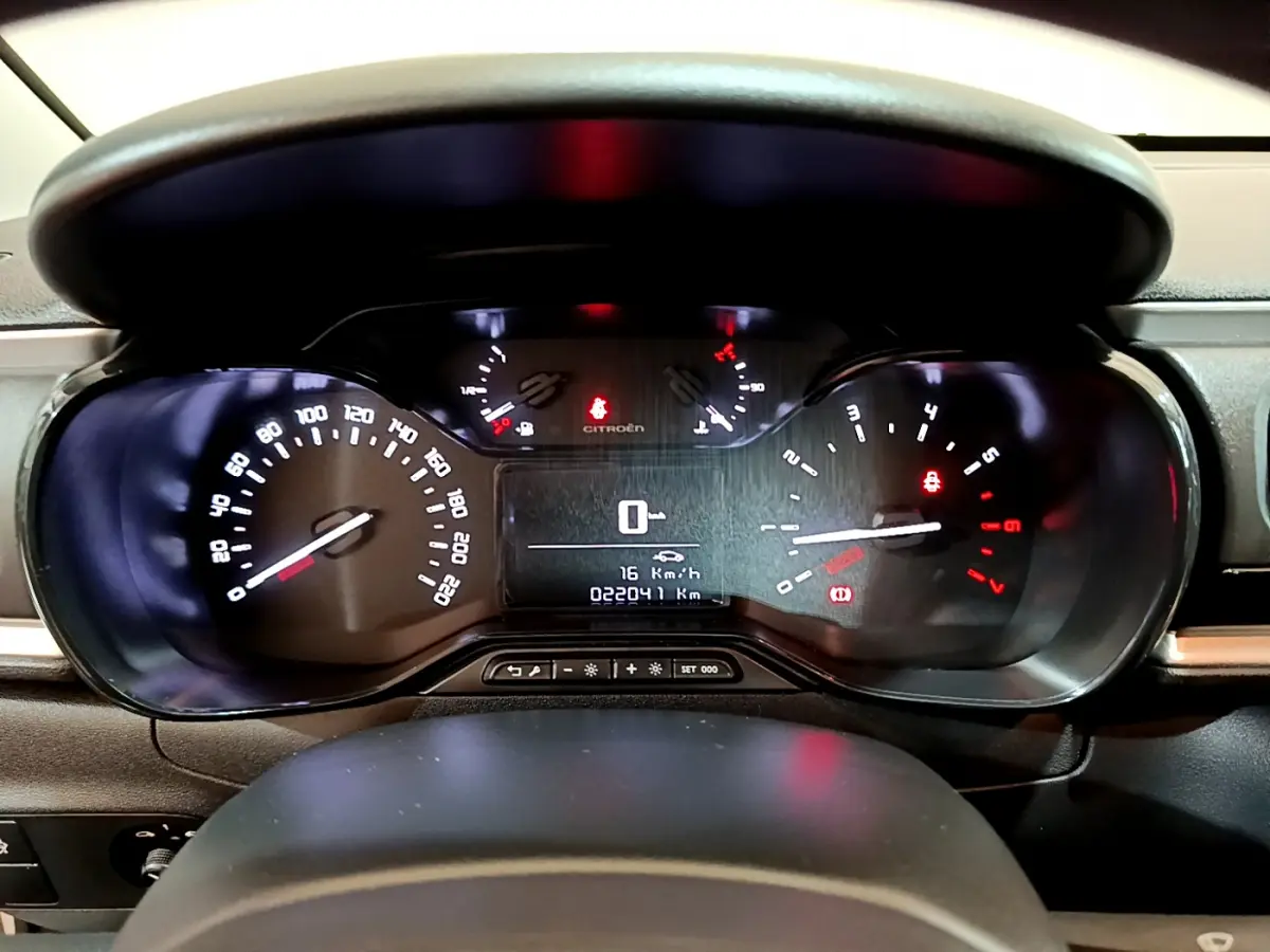 Tableau de bord de Citroën C3 blanc 2018, affichage numérique et compteurs analogiques éclairés, vue frontale rapprochée.