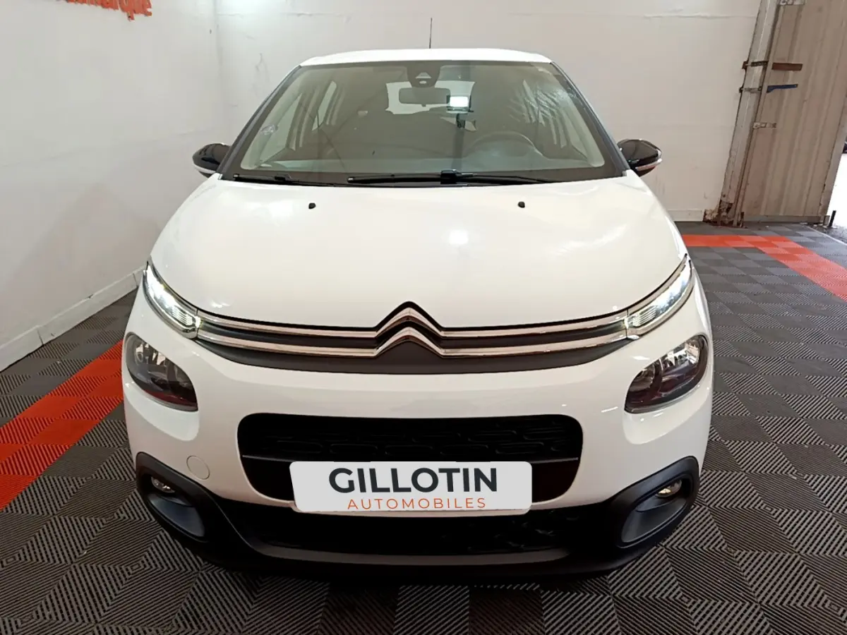 Vue frontale d'une Citroën C3 blanche 2018 avec phares LED et calandre noire contrastante.