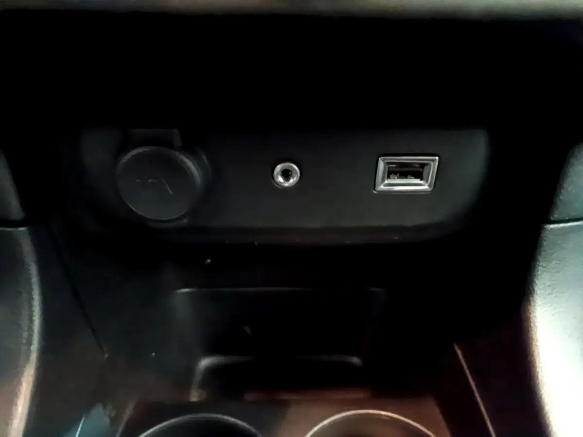 Prise USB, prise jack et prise 12V noires dans la console centrale d'une Citroën C3 PureTech 68 BVM Feel 2018.