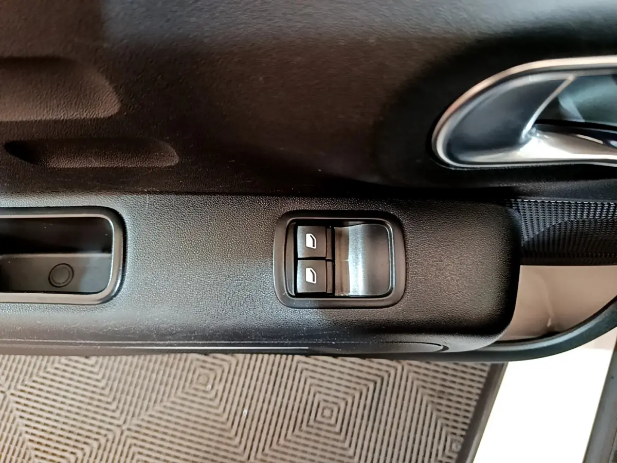 Gros plan sur la commande des vitres électriques côté conducteur de la Citroën C3 blanche PureTech 68 BVM Feel 2018.