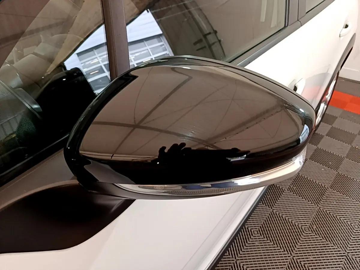 Rétroviseur noir brillant côté conducteur d'une Citroën C3 blanche PureTech 68 BVM Feel vue de près.