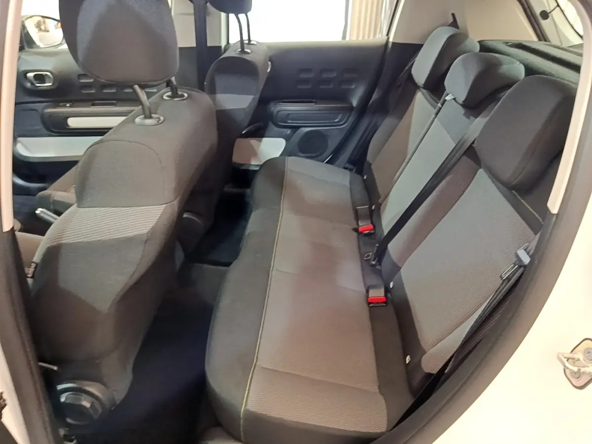 Vue intérieure côté droit de la banquette arrière grise et noire de la Citroën C3 blanche 2018 PureTech Feel.