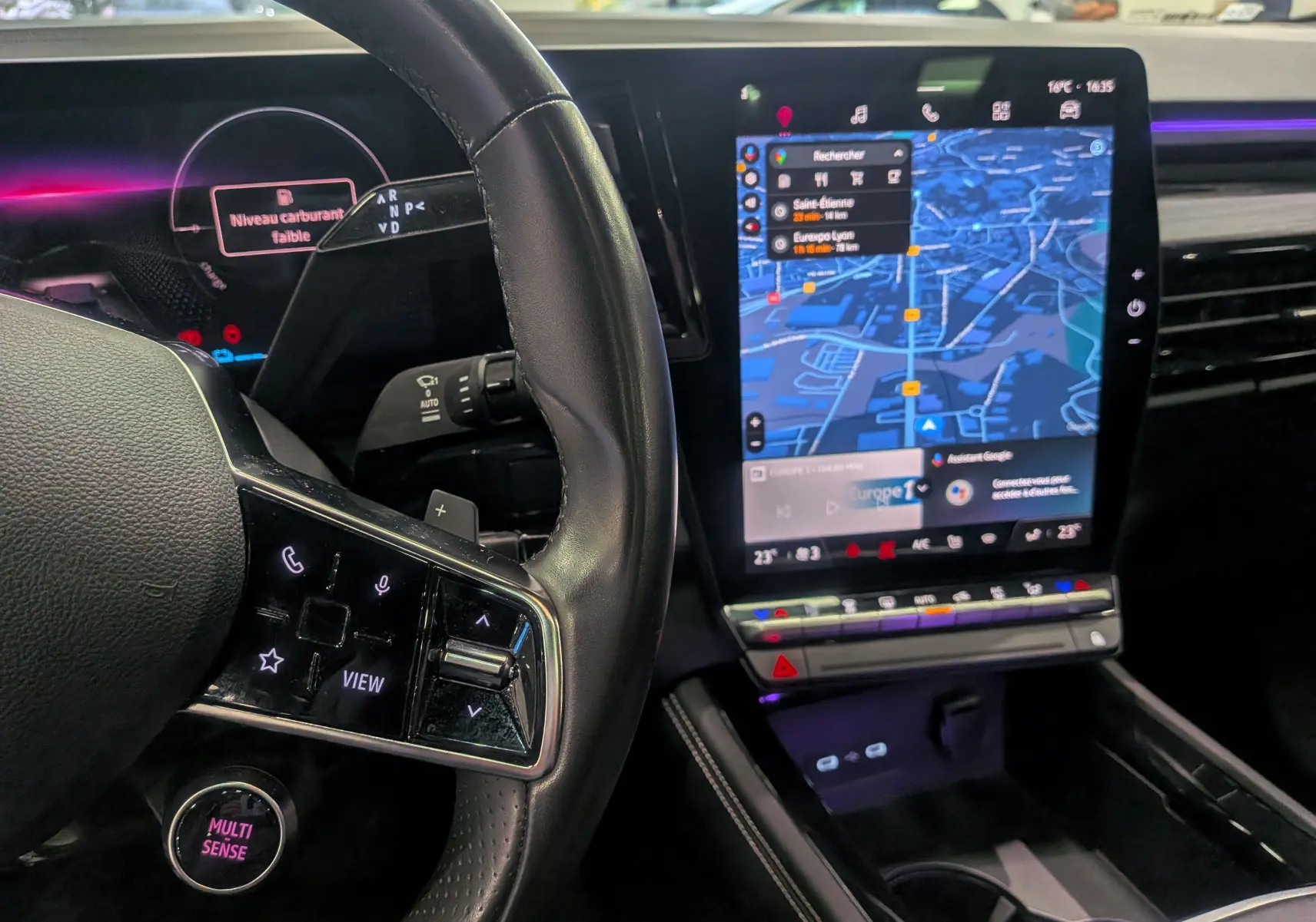 Intérieur du Renault Austral E-Tech Hybrid 2024, vue du tableau de bord avec écran tactile vertical et volant cuir noir.