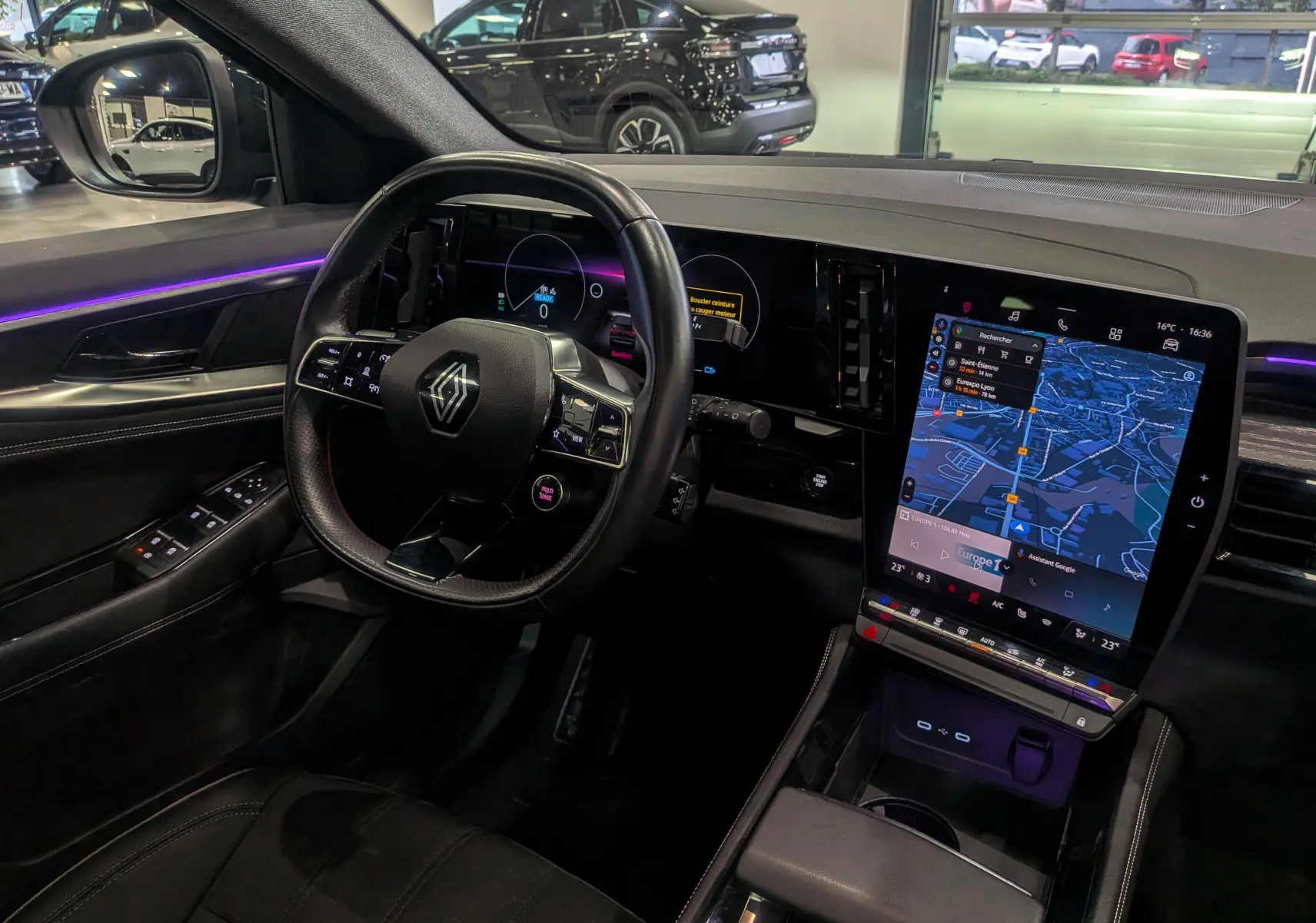 Intérieur du Renault Austral E-Tech Hybrid 2024 vu côté conducteur, avec tableau de bord numérique et écran tactile central lumineux.