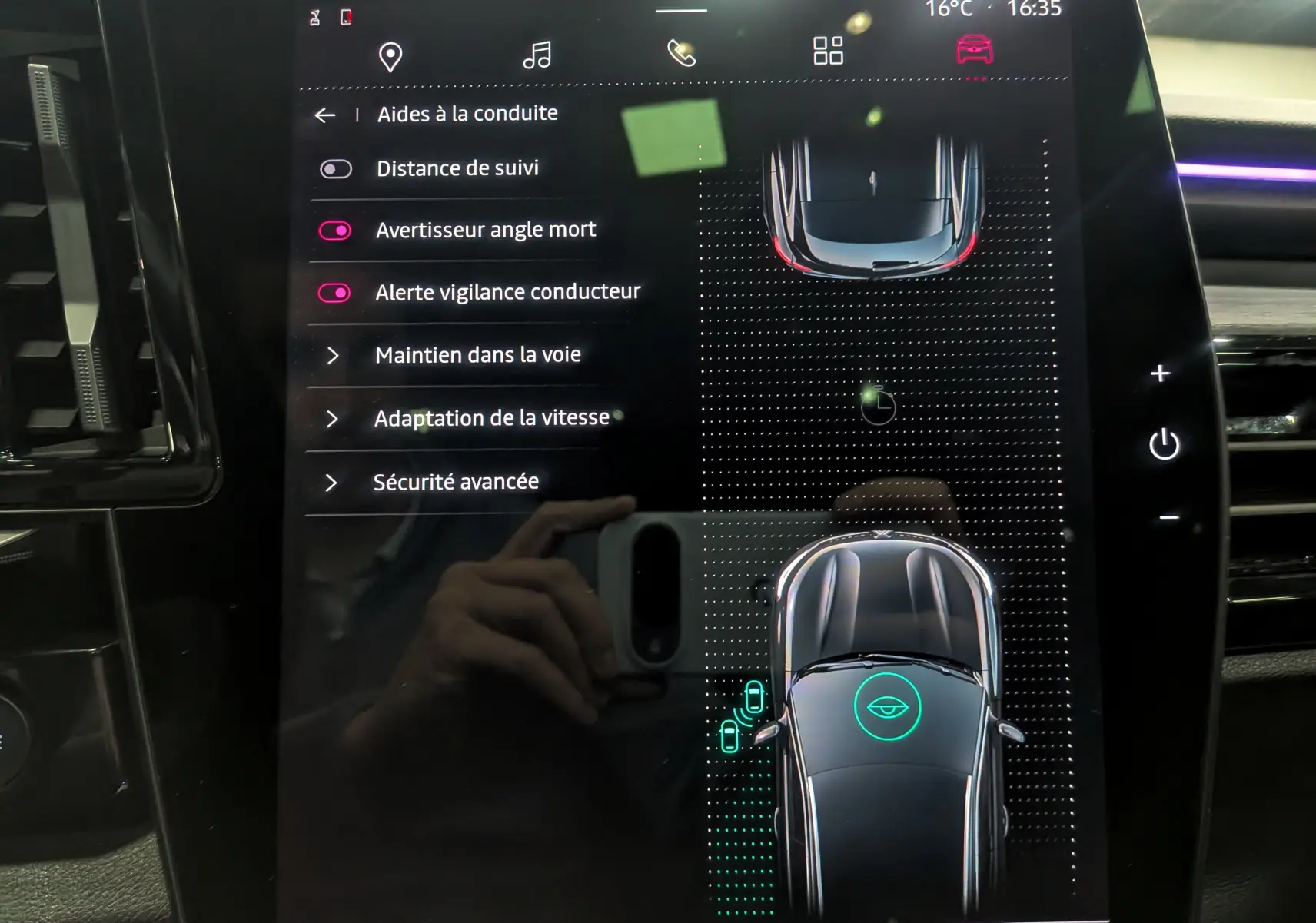 Écran tactile intérieur du Renault Austral E-Tech Hybrid 2024 montrant les aides à la conduite et la vue du véhicule en plan supérieur.