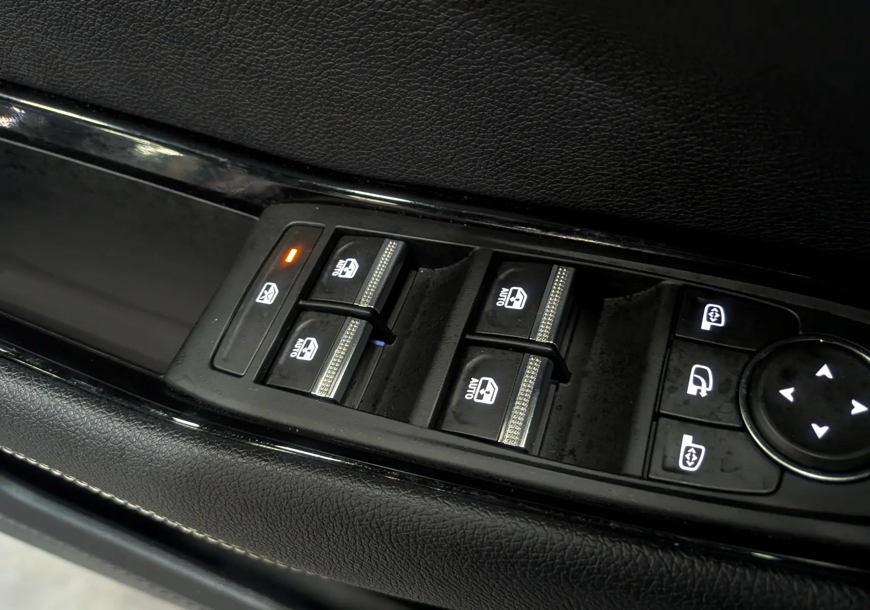 Gros plan sur les commandes de lève-vitres et rétroviseurs sur la porte côté conducteur d'un Renault Austral Bleu Iron.