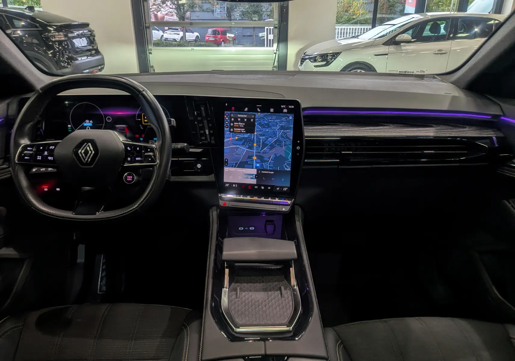 Intérieur du Renault Austral E-Tech Hybrid 2024, tableau de bord moderne avec écran tactile vertical et éclairage d'ambiance violet.