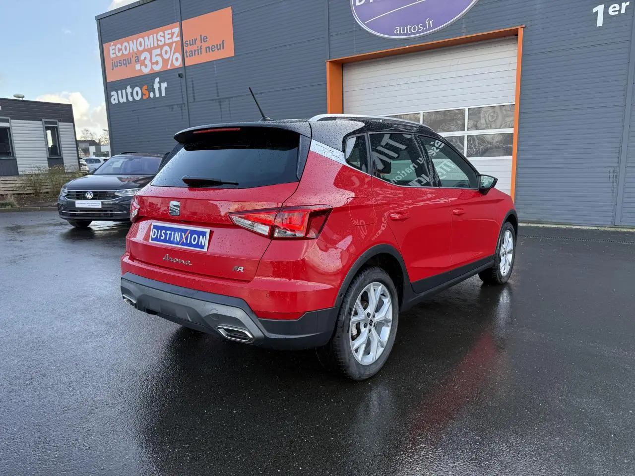Vue 3/4 arrière droite d'un SEAT Arona FR 2024 rouge pur avec jantes argentées et vitres arrière surteintées.