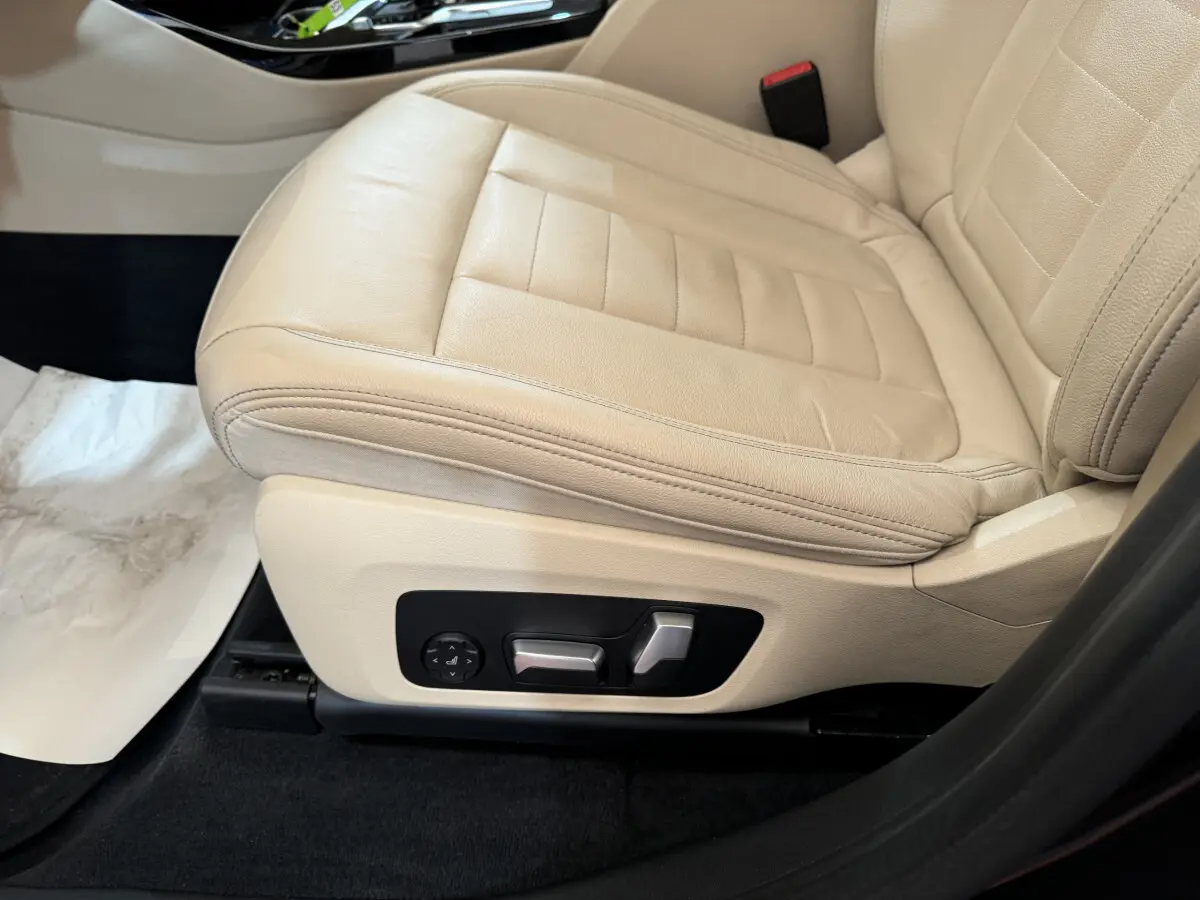 Gros plan sur le siège conducteur beige clair du BMW X3 xDrive30d 2018 avec commandes électriques latérales.