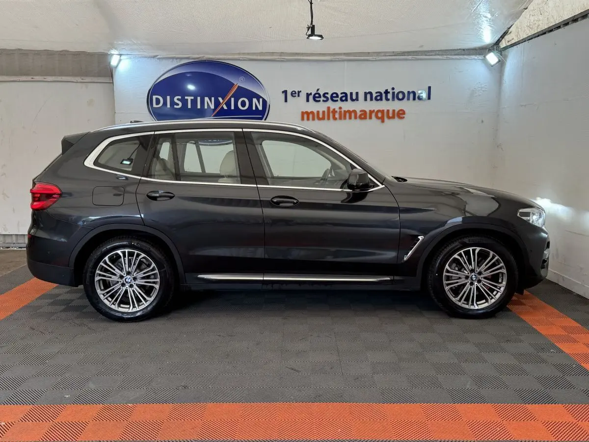 BMW X3 xDrive30d gris foncé vue de profil côté gauche, avec jantes alliage et détails chromés sur les bas de caisse.